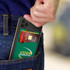 A dual silicone phone wallet in green, holding a credit card, positioned in the back pocket of jeans.