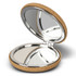 A compact mirror with a cork exterior and a shiny silver interior, featuring two reflective surfaces.