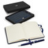 A navy blue notebook with lined pages and a matching pen, presented in a sleek black gift box.