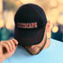 A black cap with red stitching, featuring the word "CITYSCAPE" in bold lettering on the front.