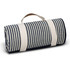 A rolled-up picnic blanket featuring navy blue and cream stripes, secured with a cream strap and handle.