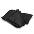 A black puffer blanket is neatly folded, showcasing its quilted texture and warm design. It has a branding logo.