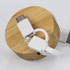 A bamboo circular base with a retractable charging cable featuring white connectors for USB-C and Lightning.