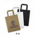 Three medium flat handle paper bags in brown, white, and black, featuring a logo on the brown bag.