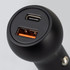 A black USB car charger featuring one USB-A port and one USB-C port. It has a round design and a sleek finish.