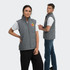 A grey puffer vest with a branding logo, displayed by two models, one male and one female.