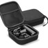 A black handheld massager and attachments stored in a black zippered case. The case features a mesh pocket.
