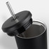 A drink bottle with a sleek black exterior, featuring a stainless steel straw and a fitted lid.