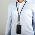 A black phone lanyard with a logo, attached to a smartphone, worn around a person's neck.