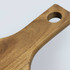 A wooden pizza board with a smooth finish and a circular hole in the handle.