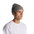 A grey knit beanie worn by a model, featuring a ribbed texture and a close-fitting design.