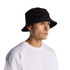 A black cord bucket hat worn by a person, facing slightly to the side, with a plain white shirt.