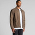 A brown canvas heavy jacket featuring two front pockets and a logo, worn by a model against a neutral backdrop.