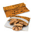 An orange reusable snack pouch with a floral design, containing chocolate chip cookies inside.
