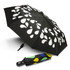 A compact umbrella with a black canopy featuring white droplet patterns and a multicoloured case.