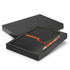 A black notebook with an orange accent and a matching pen, packaged in a black gift box.