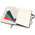 A Moleskine 2026 Weekly Planner with black covers, featuring blank pages and decorative inserts in various colours.