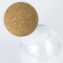 A cork ball hovering above a clear glass, featuring a natural brown colour and smooth surface.