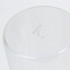 A transparent glass canister with a smooth rim and a subtle logo on the top.