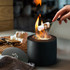 A black s'mores kit with a flame, featuring marshmallows and graham crackers on a tray.