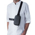 A black crossbody mini bag with a quilted design, worn over a white shirt. It features an adjustable strap and a zip closure.