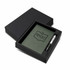 A green notebook and silver pen set in a black gift box, featuring a logo on the notebook.
