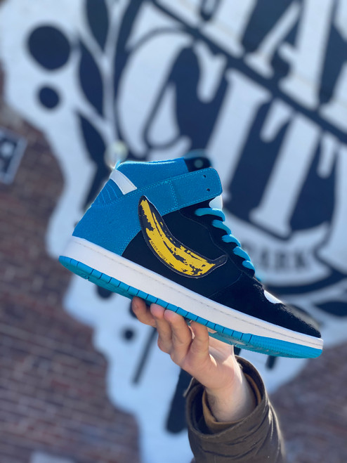 The Consolidated Drunk High BS Ultra rare collector series is a high top shoe with a comfy padded tongue, cupsole construction and a blue white and black colorway with the banana swoosh.