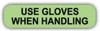 Light green rounded rectangle stickers with black text USE GLOVES WHEN HANDLING