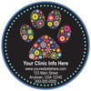 Circle veterinary sticker featuring a colorful floral paw print on a black background with blue border accents and customizable clinic information.

