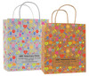 White and kraft veterinary handled bags with colorful pet icon pattern including paw prints bones hearts and a centered label panel