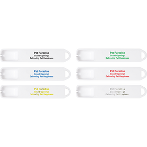 Pet Paradise personalized tick remover spoons with stacked text reading "Grand Opening!" and "Delivering Pet Happiness" displayed in black, green, blue, red, yellow, and gray imprint colors on white spoons.