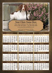 Dog and tabby cat sitting outdoors beside pink flowering plants and rustic wood background above a year calendar with personalized business imprint panel.