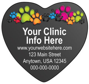 Heart-shaped veterinary sticker with colorful paw print graphics along the top border, white clinic information text, and a dark gray background.

