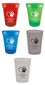 Personalized pet food measuring cup featuring a heart outline and paw print graphic above the phrase "We love pets!" with custom clinic name, address, phone number, fax number, and website information.
