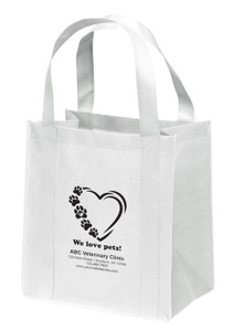 Reusable non-woven tote bag with paw prints forming a heart outline and “We love pets!” text above clinic information layout.