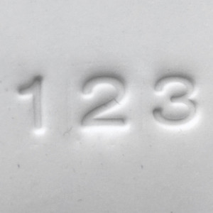 Close-up of number impressions 1, 2, and 3 pressed into clay using the Pawprint Impression Kit Number Stamp Set with bold block style characters.

