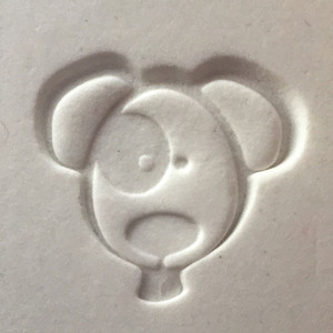 Metal Dog impression stamp creating a cat-shaped design in white clay, shown as an accessory for pet memorial and keepsake impression kits.

