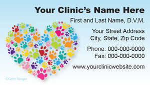 Veterinary business card featuring a heart shape made from colorful paw prints on a light blue background with clinic contact information.

