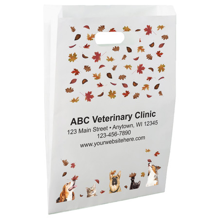 White die-cut handle paper bag featuring scattered autumn leaves above dog and cat portraits positioned along the bottom edge of the design.

