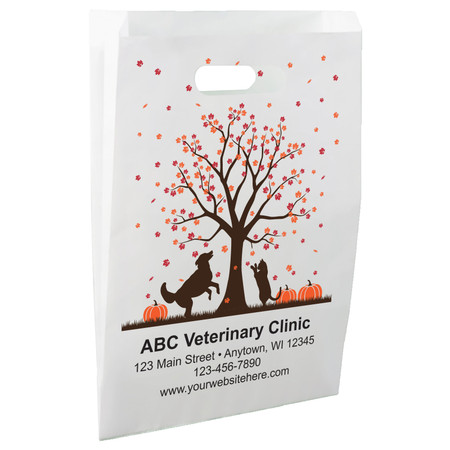 White die-cut handle paper bag featuring an autumn tree with orange leaves, dog and cat silhouettes, and orange pumpkins.

