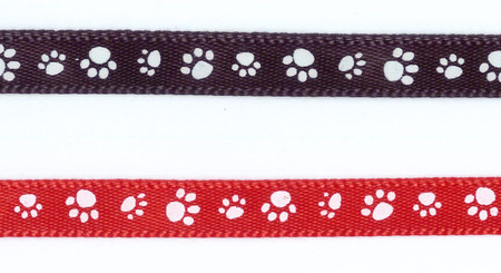 Black memorial ribbon with white paw print pattern and red ribbon with white paw prints both for ClayPaws keepsakes and pet remembrance displays.