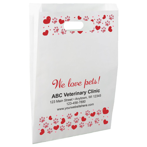 White die-cut handle paper bag featuring red heart borders, pink paw prints with heart accents, and the decorative message "We love pets!"

