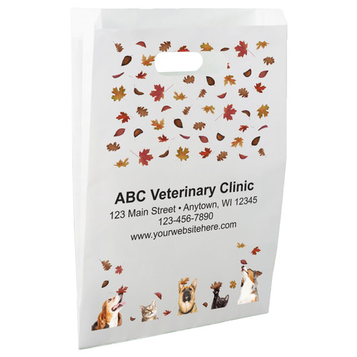 White die-cut handle paper bag featuring falling autumn leaves and dogs and cats looking upward from the bottom border.

