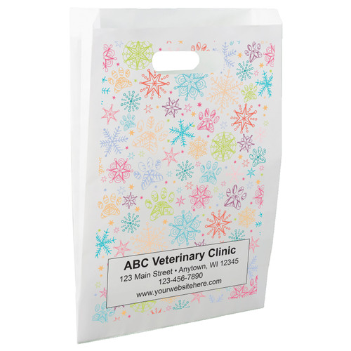 White die-cut handle paper bag featuring colorful snowflakes, paw prints, and stars in a winter-themed pattern.

