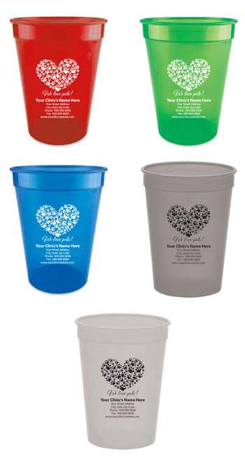 Personalized pet food measuring cup featuring a heart shape created from multiple paw prints above the phrase "We love pets!" with custom clinic name, address, phone number, fax number, and website information.