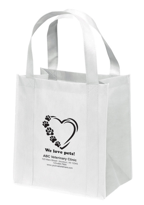 Reusable non-woven tote bag with paw prints forming a heart outline and “We love pets!” text above clinic information layout.