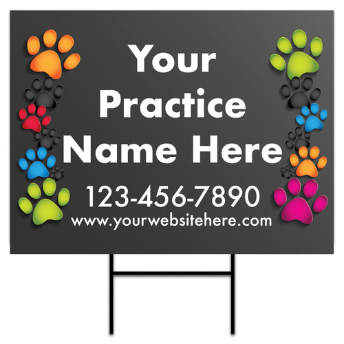 18" x 24" personalized yard sign featuring large white custom text centered on a dark gray background with colorful paw print graphics arranged vertically along both sides and an included H-stake.