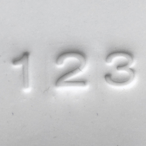 Close-up of number impressions 1, 2, and 3 pressed into clay using the Pawprint Impression Kit Number Stamp Set with bold block style characters.

