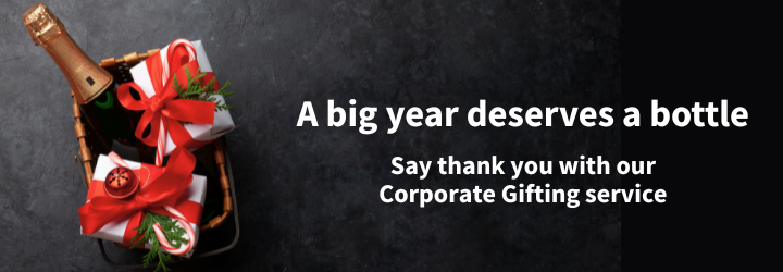 A bottle of Champagne and gifts in a basket.