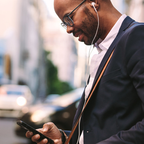 Man listening to headphones holding a phone